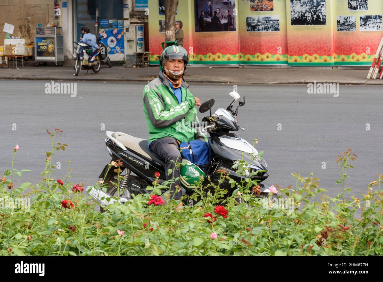 Un chauffeur de taxi moto Grab attend les passagers dans les rues de Ho Chi Minh-ville (Saigon), du sud du Vietnam, de l'Asie du Sud-est Banque D'Images