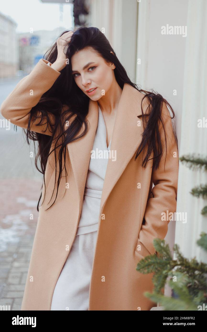 La jeune femme brune en manteau d'hiver beige est seule dans la rue. Ville  Street mode, femme élégant look Photo Stock - Alamy