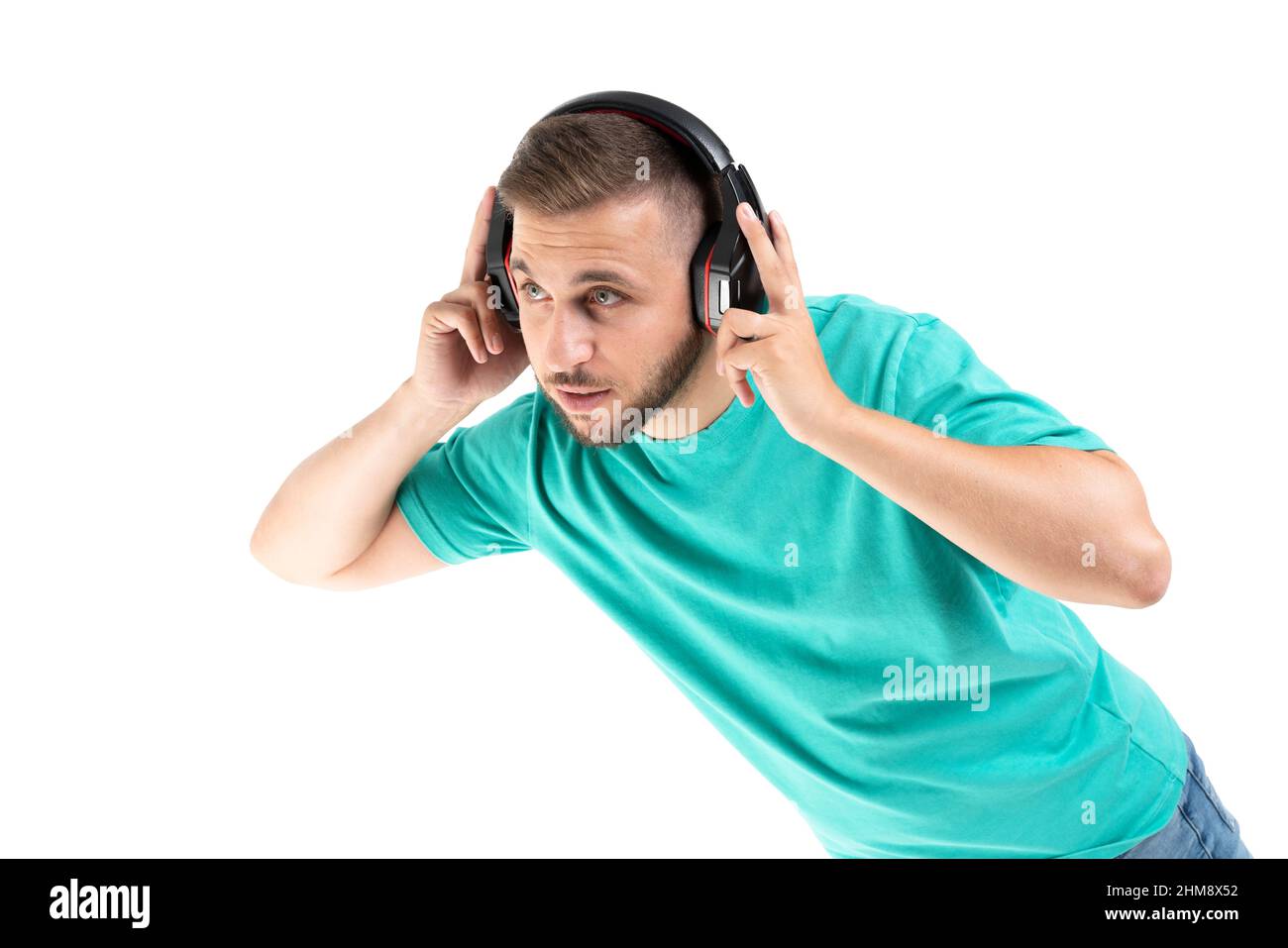 Jeune homme écoutant de la musique avec un casque noir sur fond blanc Banque D'Images