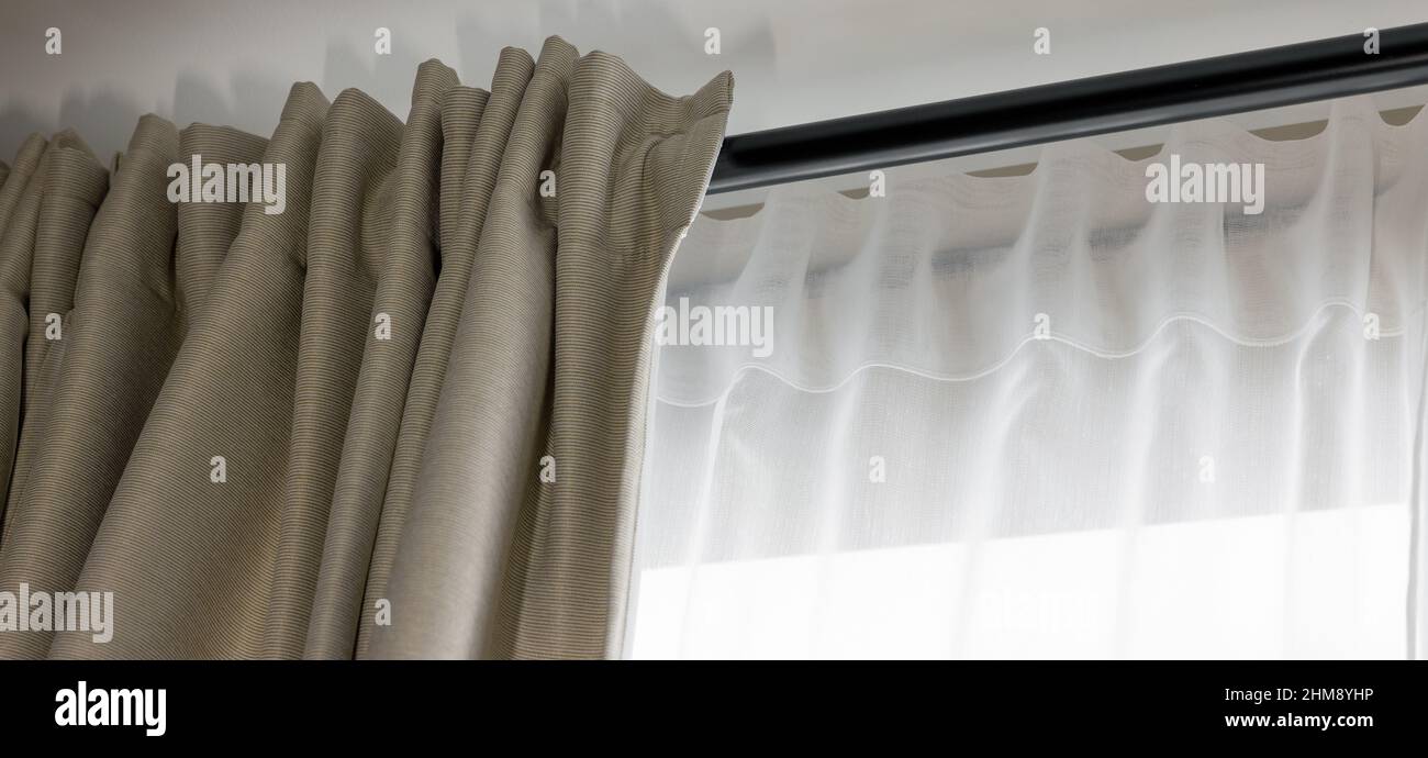 double couche de rideaux de jour et de nuit sur tige noire dans la salle de séjour Banque D'Images