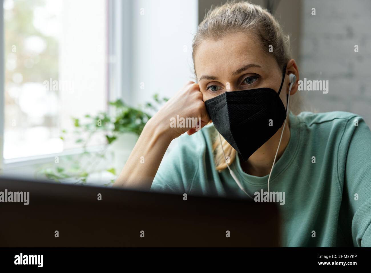 Femme avec FFP2 masque de visage travaillant avec un ordinateur dans le bureau. Sécurité au travail Banque D'Images