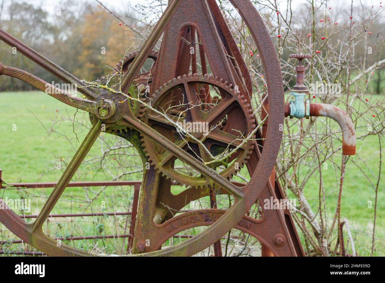 Des fûts et des roues d'époque de machines agricoles usées et roueuses, une pompe à eau de puits située dans un champ de Vann, près d'Ockley, Surrey, en hiver Banque D'Images