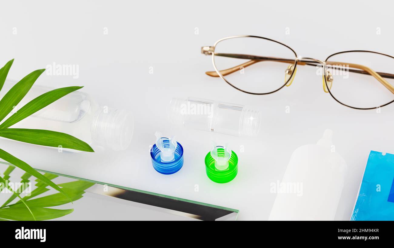 Kit de lentilles de contact avec lentilles, conteneur, lunettes et gouttes pour les yeux sur une table blanche avec espace de copie. Le concept de l'utilisation correcte des lentilles de contact et de nuit Banque D'Images