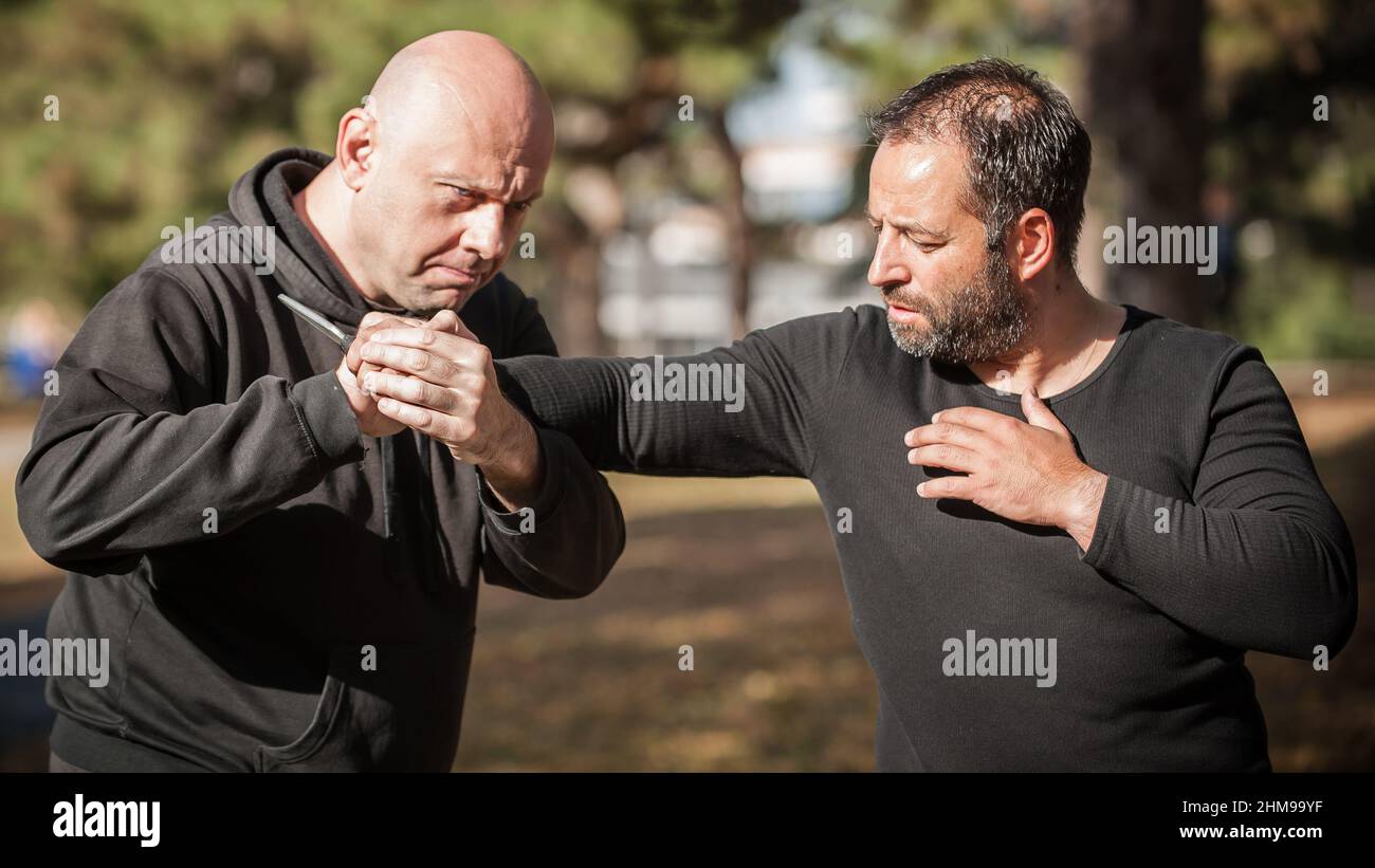 Menace de couteau.L'instructeur de Kapap démontre la technique de désarmement d'auto-défense des arts martiaux contre l'attaque au couteau.Formation de désarmement des armes.Démonstration Banque D'Images