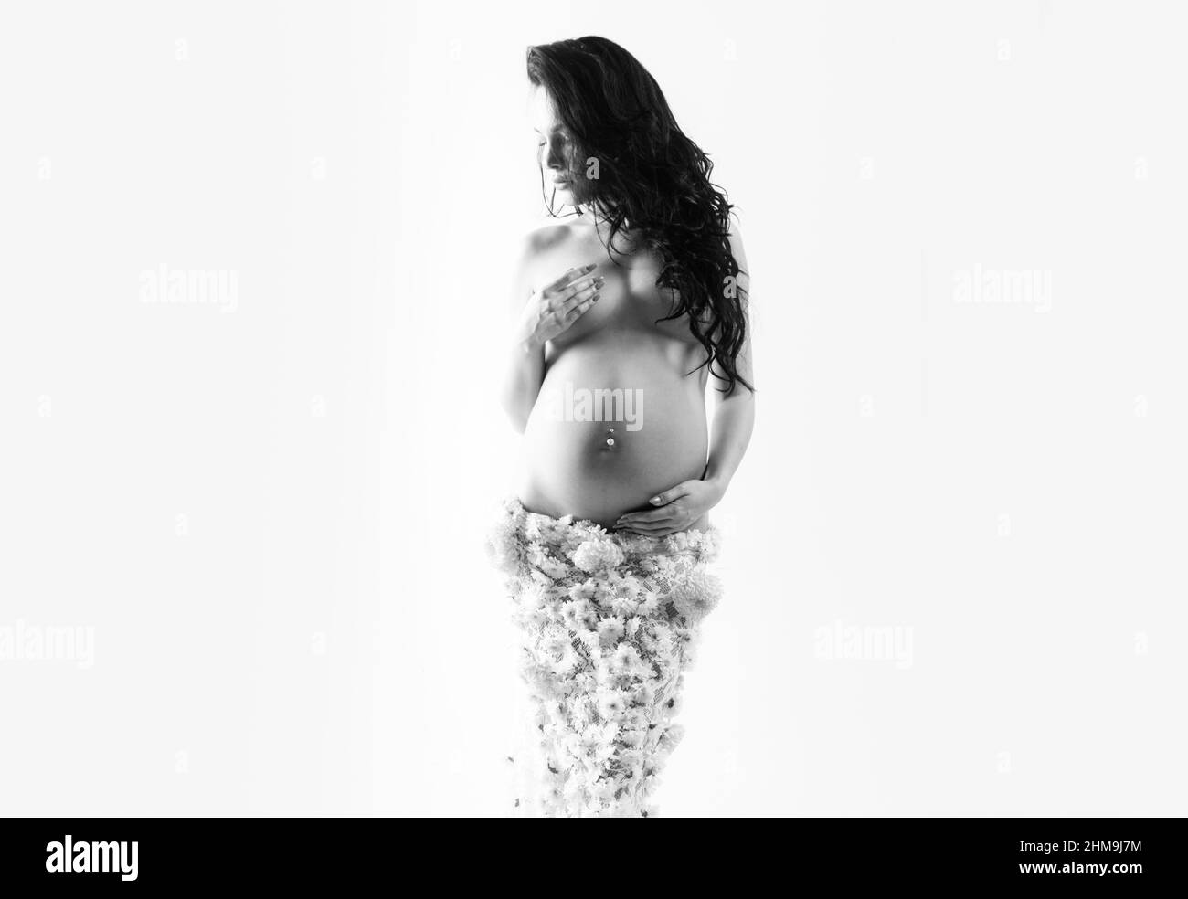 belle femme enceinte en jupe de fleur de printemps. santé des femmes. fille avec grand ventre. espérance de vie à la naissance. Amour. Future mère a bébé à l'intérieur Banque D'Images