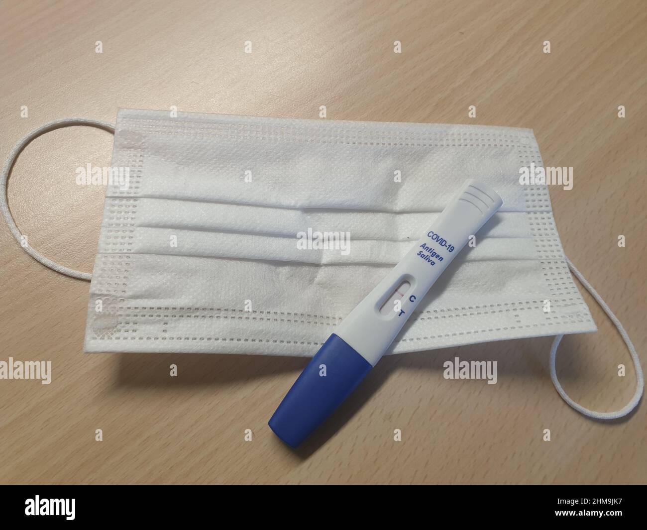 Un masque facial médical et un kit de test rapide du débit latéral de l'antigène COVID-19 (salive) montrant un résultat négatif, il est également connu sous le nom de test de lipop Banque D'Images