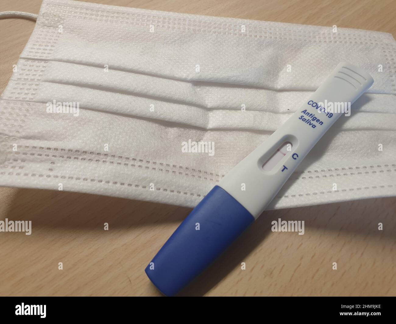 Un masque facial médical et un kit de test rapide du débit latéral de l'antigène COVID-19 (salive) montrant un résultat négatif, il est également connu sous le nom de test de lipop Banque D'Images