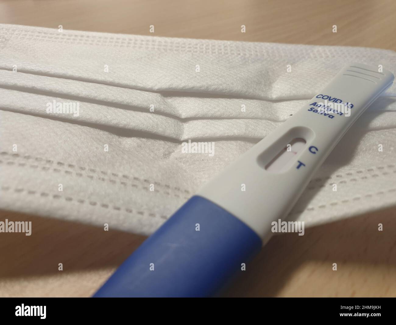 Un masque facial médical et un kit de test rapide du débit latéral de l'antigène COVID-19 (salive) montrant un résultat négatif, il est également connu sous le nom de test de lipop Banque D'Images