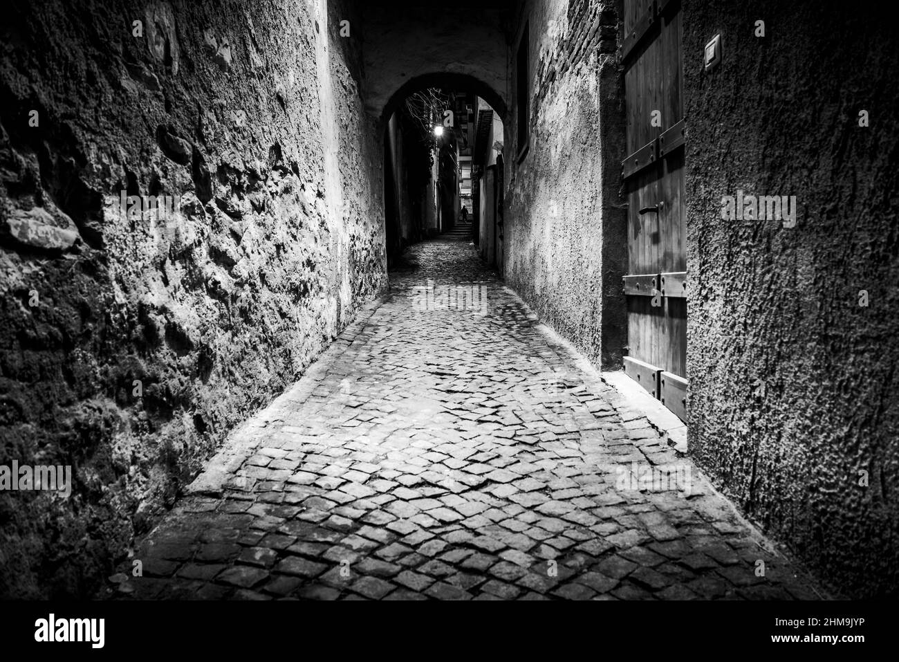 rue étroite la nuit éclairée par un lampadaire avec une personne qui marche de retour à l'arrière Banque D'Images