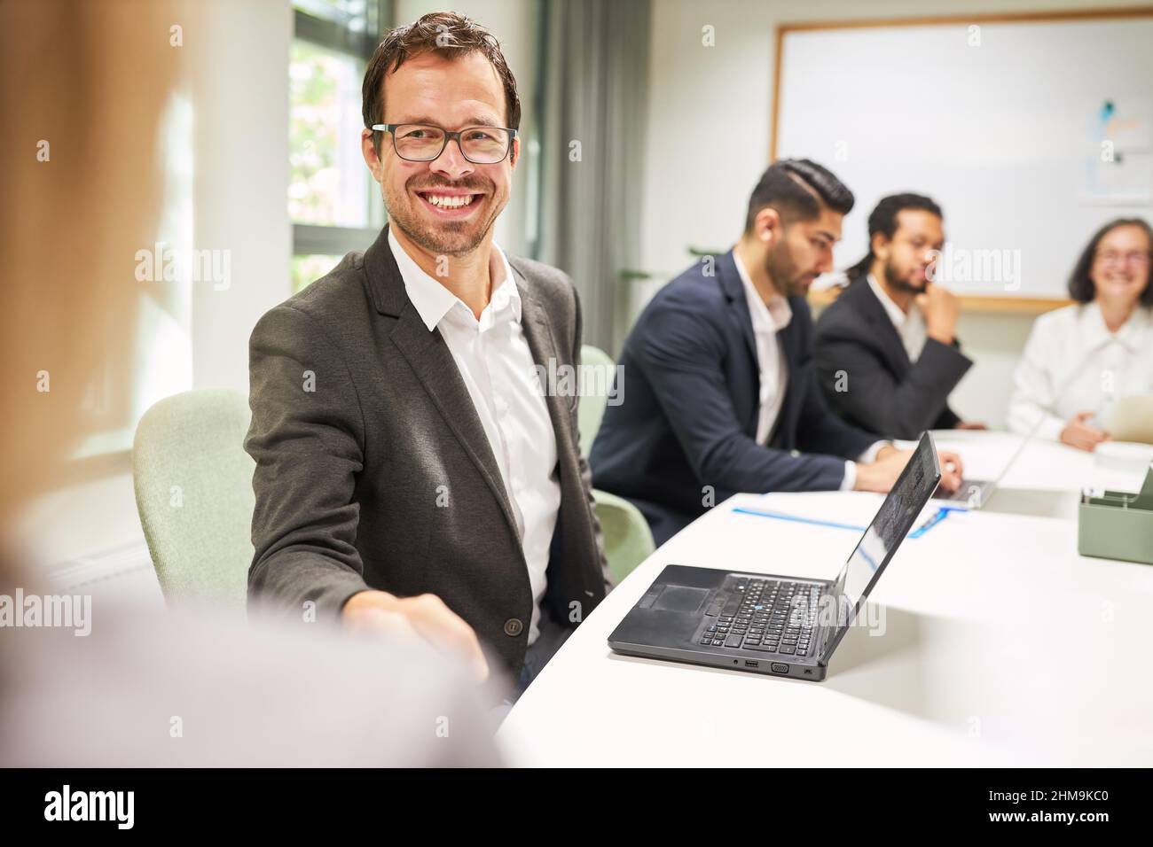 Un homme d'affaires heureux qui se fait le plaisir de se faire les mains après une négociation dans une réunion d'affaires Banque D'Images