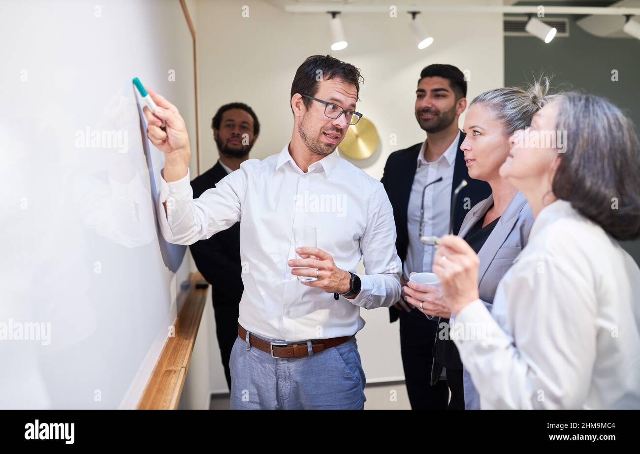 Intervenant ou consultant présentant une présentation pour l'équipe de démarrage sur le tableau blanc dans la salle de conférence Banque D'Images