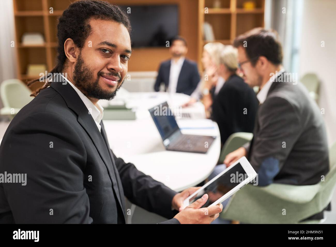 Homme d'affaires africain en tant que gestionnaire confiant avec un ordinateur tablette dans la réunion Banque D'Images