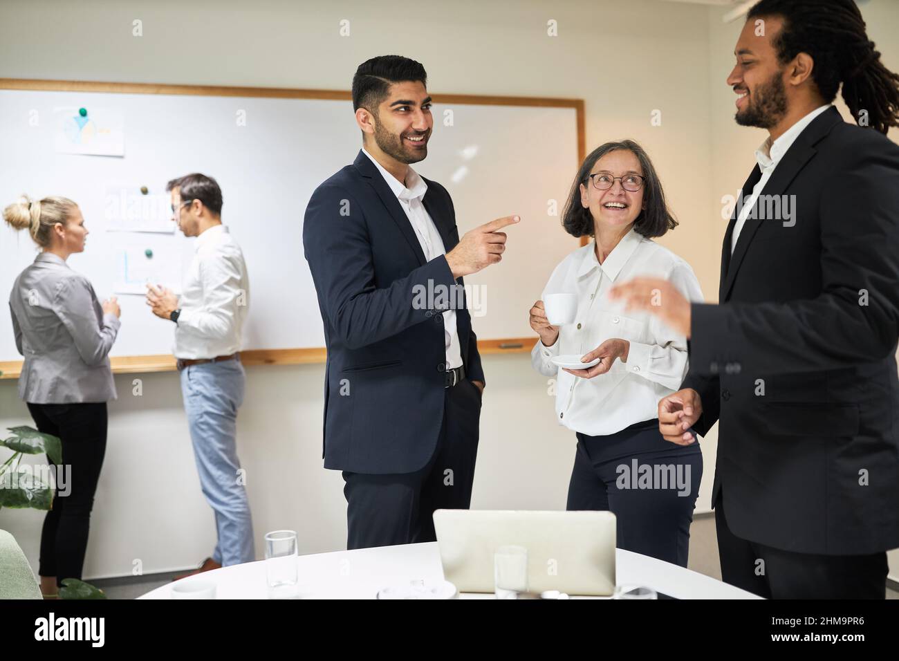 Les jeunes gens d'affaires de l'équipe de démarrage internationale ont des discussions animées sur le PC dans la salle de conférence Banque D'Images