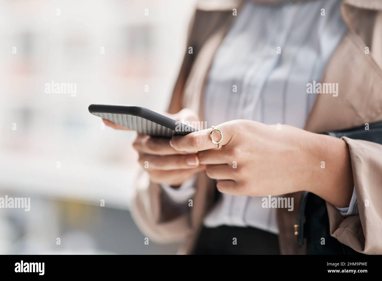 Il est plus facile de se déplacer lorsque vous avez le monde à portée de main. Prise de vue rognée d'une femme méconnaissable utilisant son téléphone portable contre une ville Banque D'Images