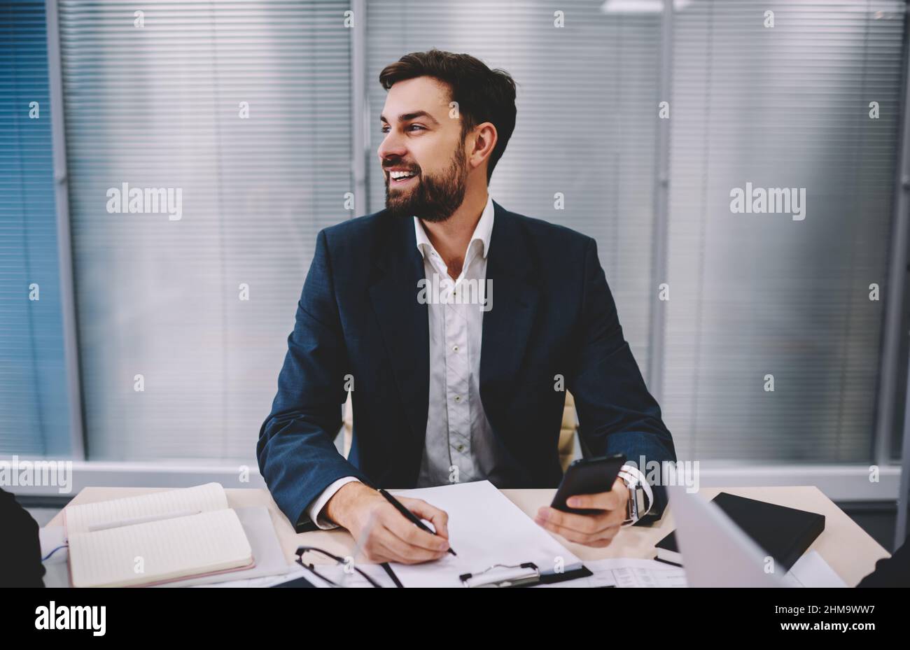 Homme d'affaires joyeux avec des documents au bureau Banque D'Images