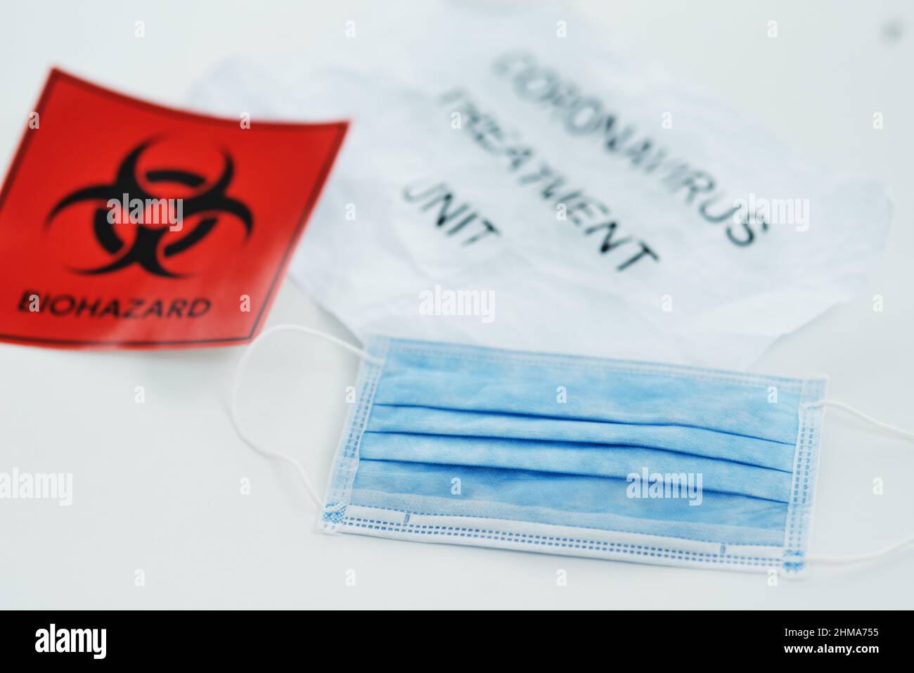 Nous sommes confrontés à une crise mondiale de la santé, contrairement à tout. Cliché d'un panneau de danger biologique et d'un masque sur fond blanc. Banque D'Images