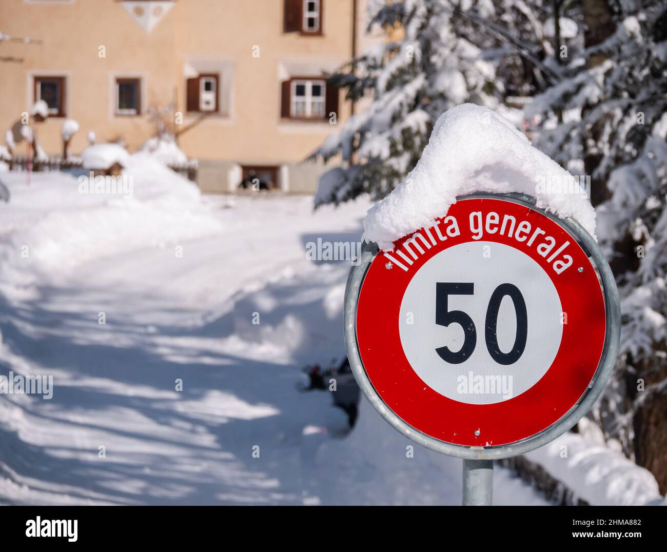 Cinuos-Chel, Suisse - 3 février 2022 : signalisation routière enneigée pour la limitation de vitesse à 50 km en romanche dans le village suisse de Cinuos-CH Banque D'Images