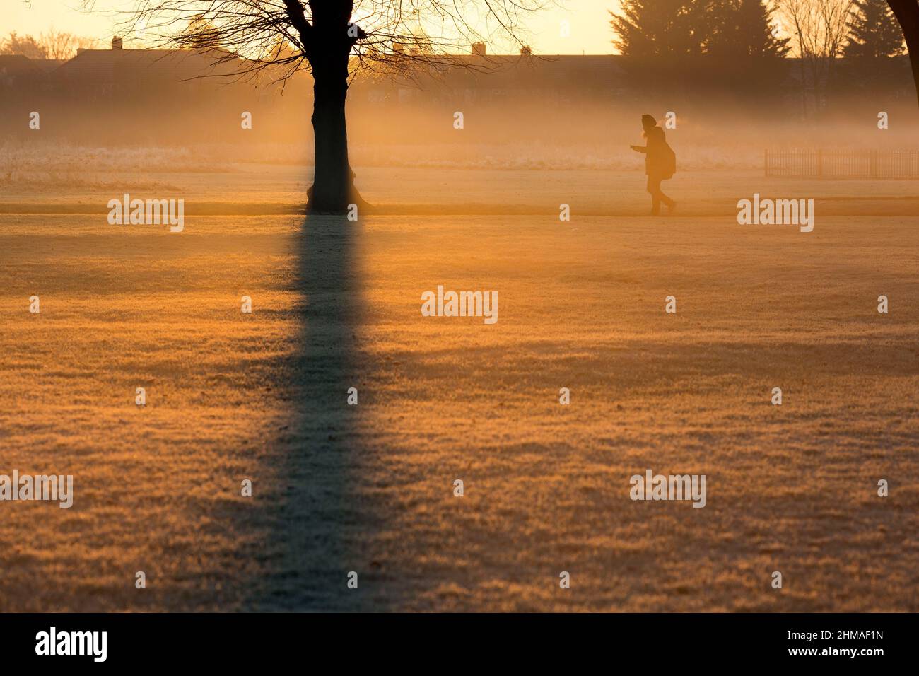 Les gens marchent dans un parc couvert de brume et de gel à Ilford, dans l'est de Londres, au lever du soleil. Banque D'Images