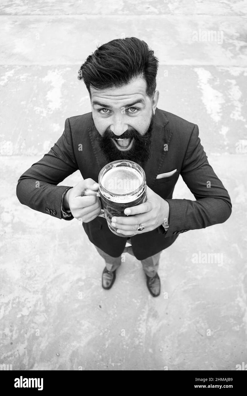 Drôle d'homme en costume classique tenant le verre avec la bière à la main. Homme souriant avec de la bière. Barman, bon brasseur. Pleine longueur, grand angle. Expression Banque D'Images