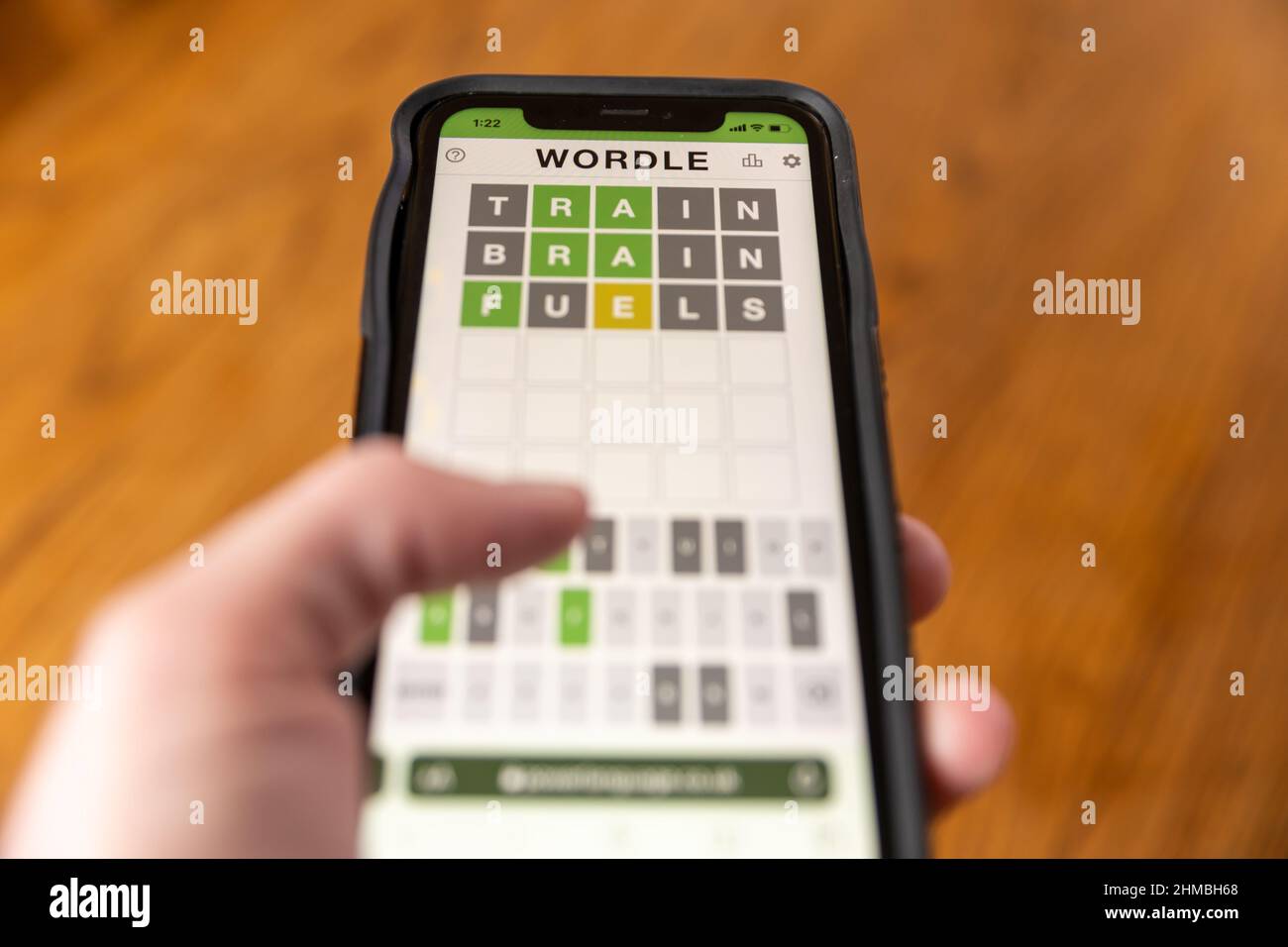 Brandon, MS - 8 février 2022: Mains jouant Wordle jeu au téléphone. Banque D'Images
