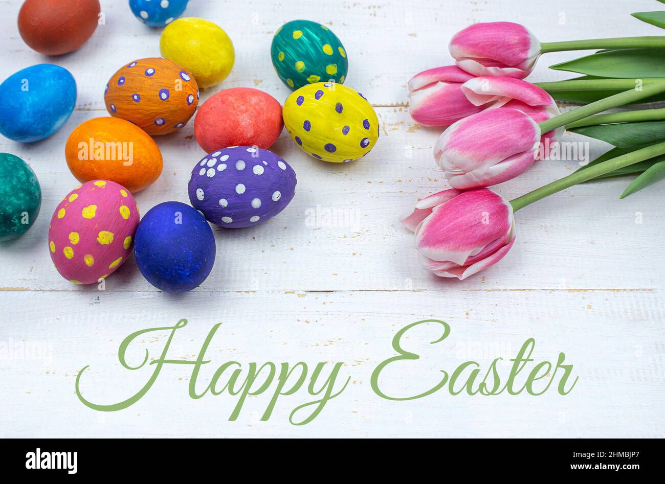 Arrière-plan de Pâques. Œufs de Pâques. Œufs de Pâques multicolores. Pâques. Œufs de Pâques sur fond de bois blanc. Tulipes et oeufs de Pâques Banque D'Images