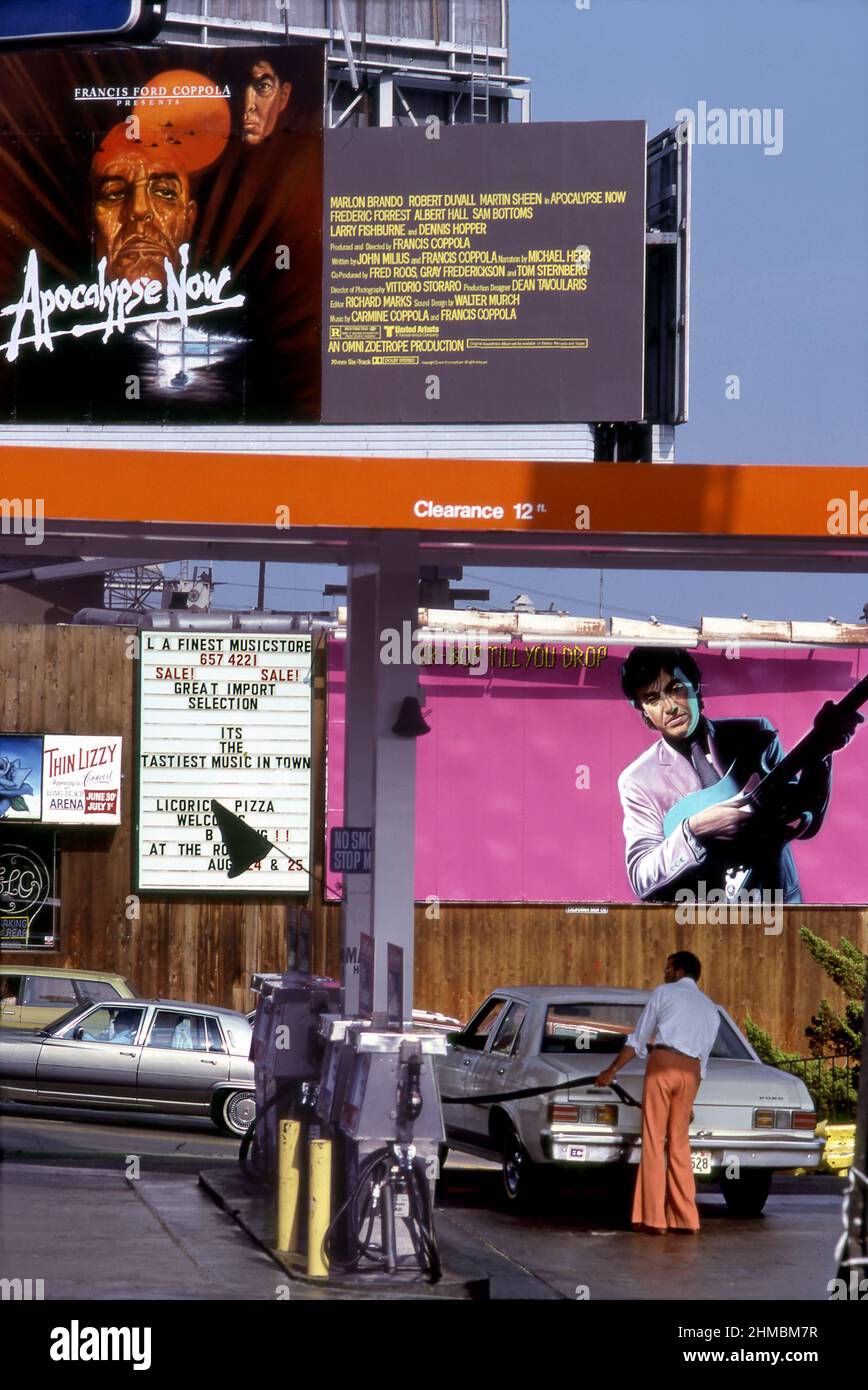 Un homme achetant de l'essence sur le Sunset Strip en 1979 avec un panneau d'affichage Apocalypse Now au-dessus du magasin de disques Licorice Pizza avec son propre panneau d'affichage pour Ry Cooder et un disque appelé Bop Tilll You Drop. Banque D'Images