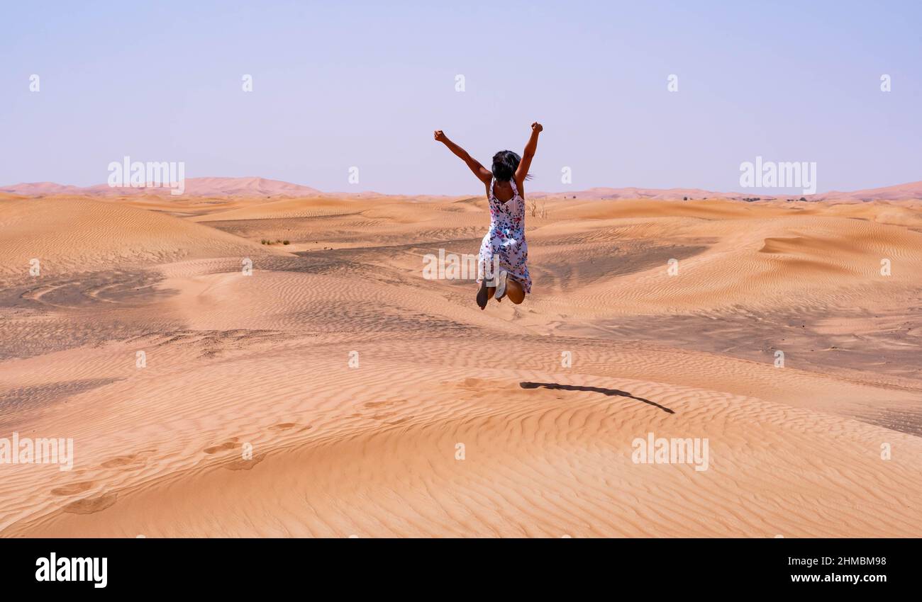 Brunette femme bondissant dans le désert Banque D'Images