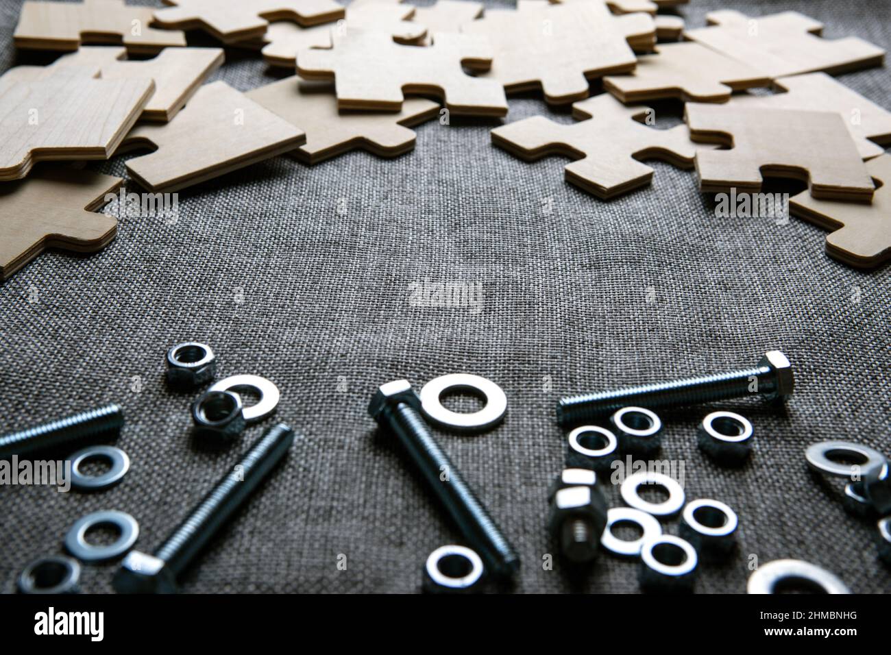 éléments de puzzle et écrous en acier, boulons sur un fond textile gros plan Banque D'Images