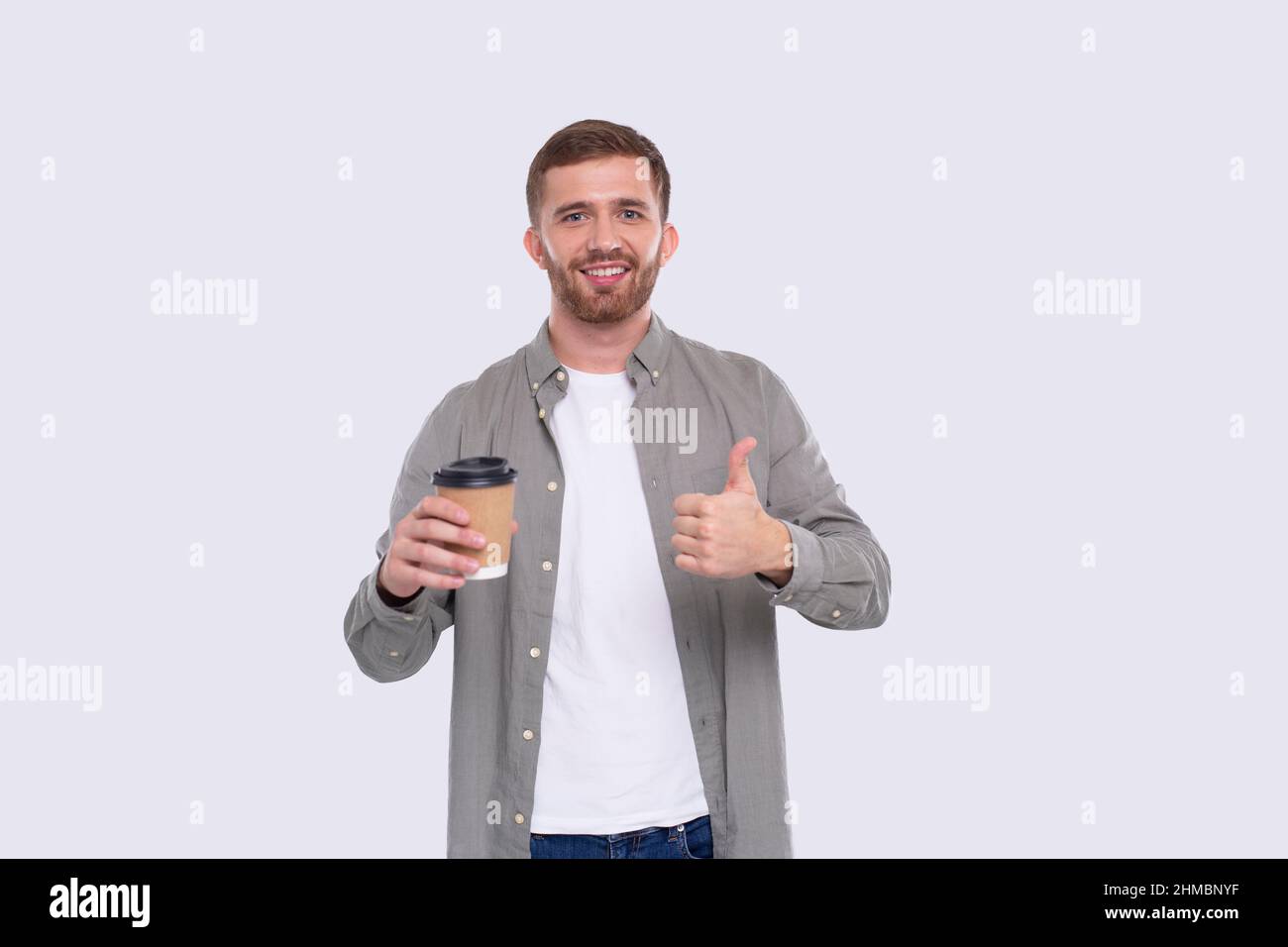 Tasse à café à emporter montrant le pouce vers le haut. Tasse à café à emporter dans les mains. Homme isolé Banque D'Images