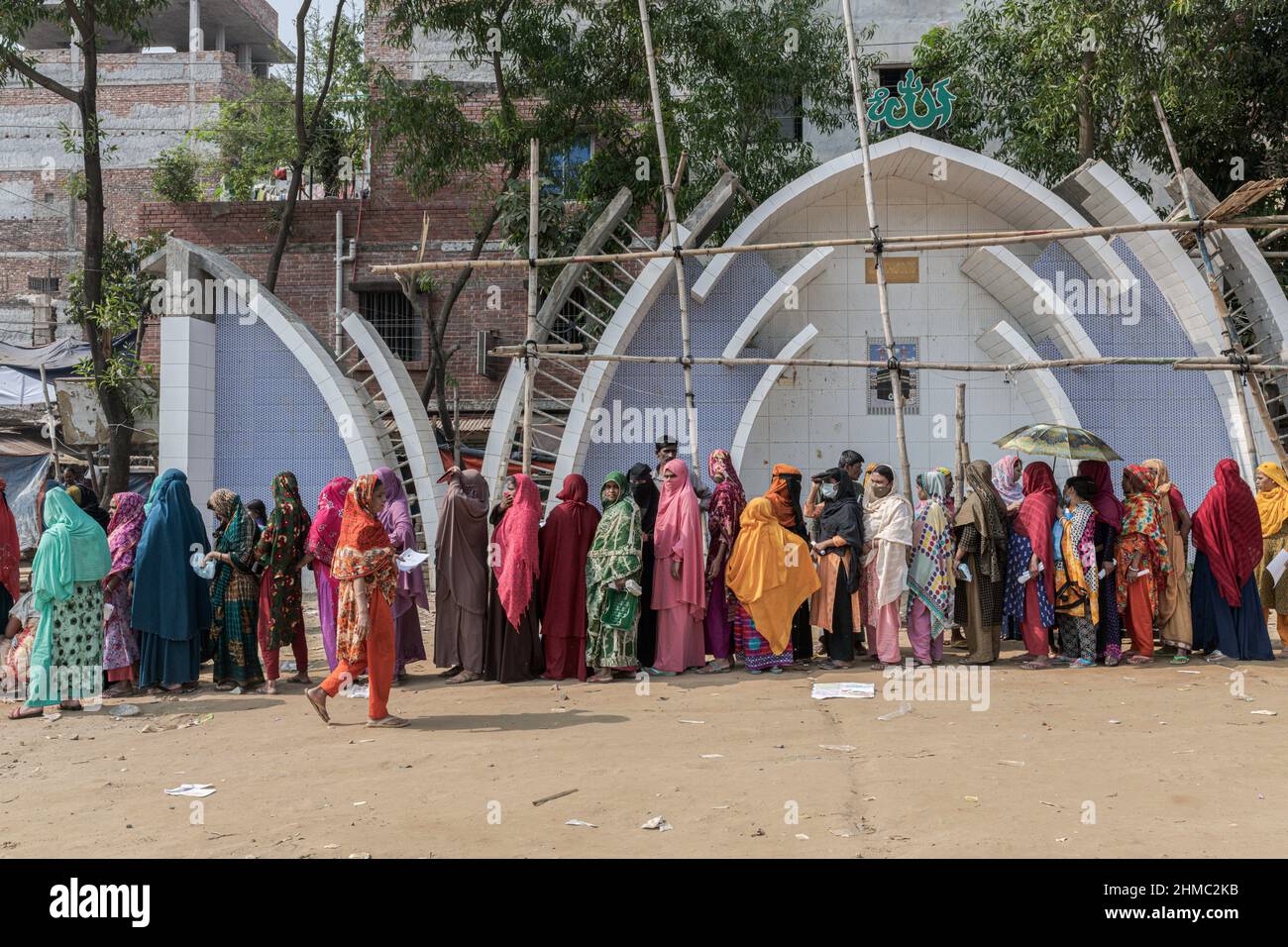 Dhaka, Bangladesh. 24th novembre 2021. Groupe de femmes qui attendent d'être vaccinées contre COVID19 lors de la campagne de vaccination à Mirpur.à Dhaka, au Bangladesh, la capitale du pays le plus densément peuplé au monde, la pandémie de COVID est une histoire chaotique depuis que les restrictions gouvernementales ont commencé à tenter de prévenir les infections et les décès. Dhaka est une mégapole croissante avec plus de 20 millions d'habitants au bruit et à la ruée quotidienne, mais sans les infrastructures nécessaires et avec plus de 60% de sa population travaillant de manière informelle et embourbée dans la pauvreté, le chaos s'est intensifié à tous les niveaux Banque D'Images