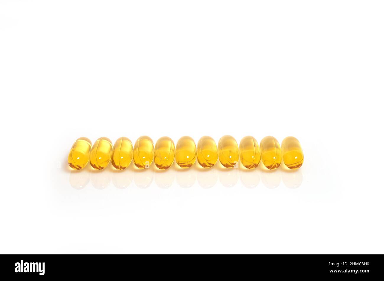 De nombreuses capsules jaunes d'huile de poisson oméga-3 se trouvent dans une rangée Banque D'Images
