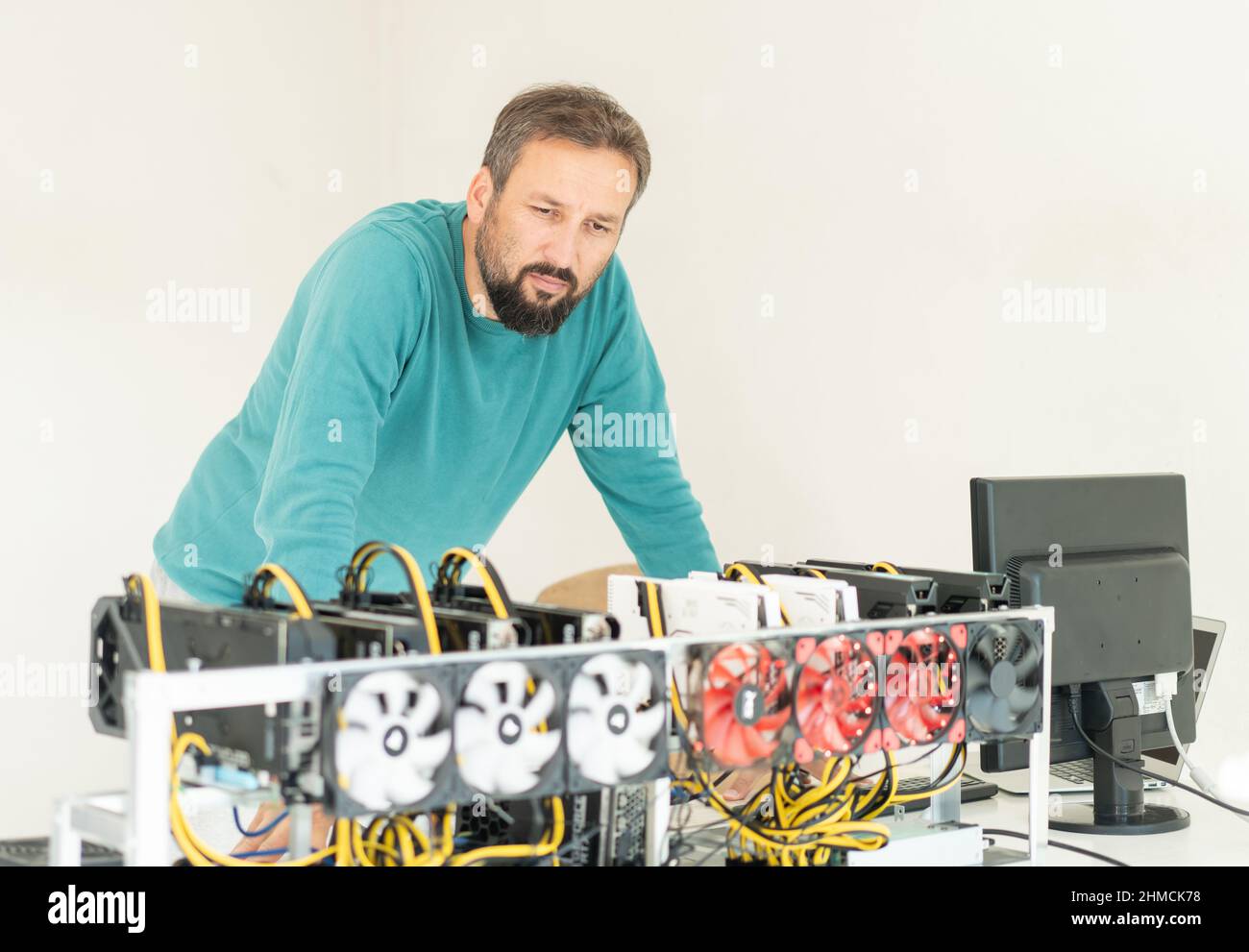 Jeune programmeur qui ajuste l'engin minier de crypto-monnaie aux paramètres opérationnels optimaux. Photo de haute qualité Banque D'Images