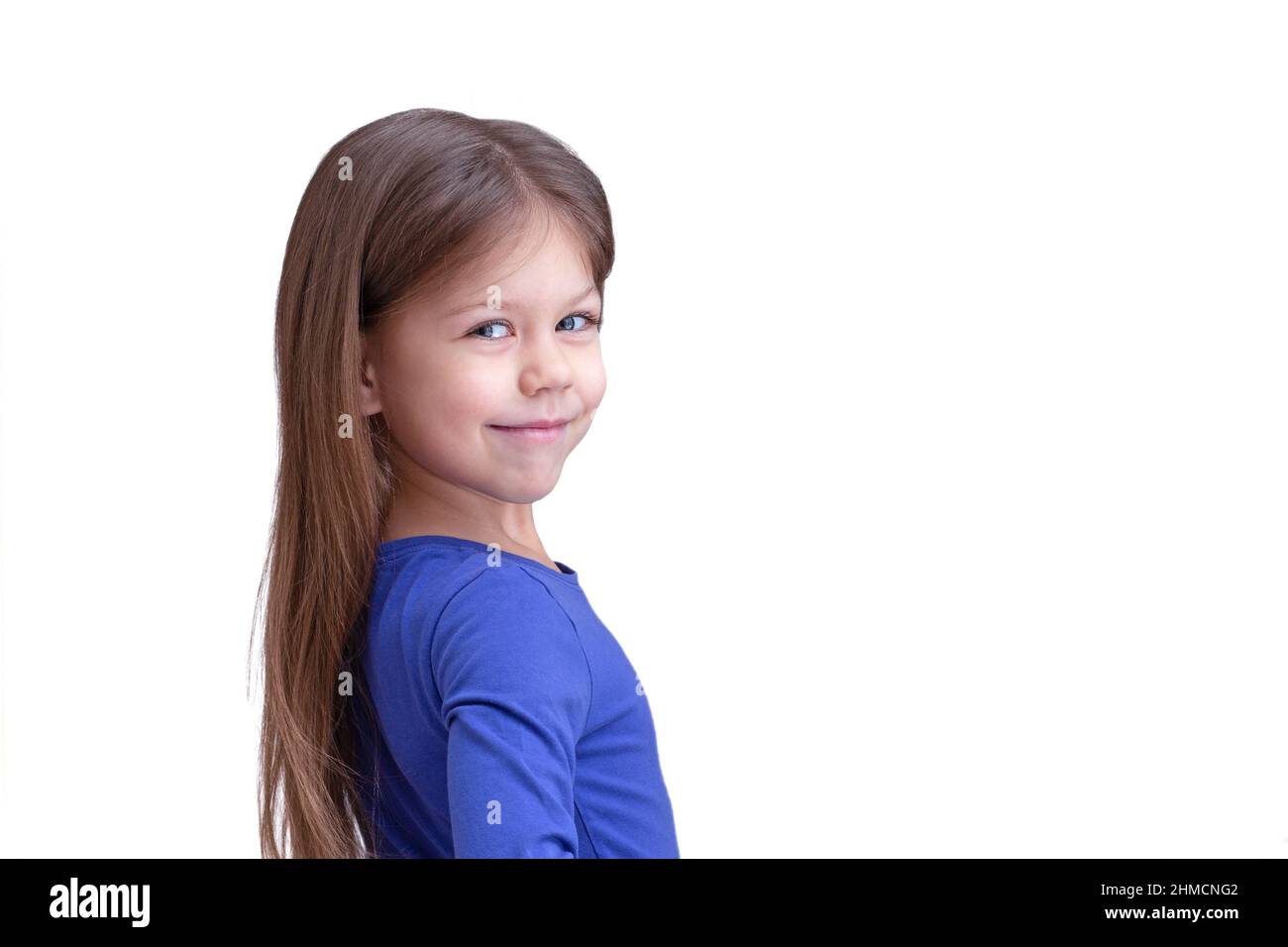 Heureux mignon enfant mi-tour isolé sur fond blanc, regardant la taille de l'appareil photo vers le haut caucasien petite fille de 5 ans en bleu Banque D'Images