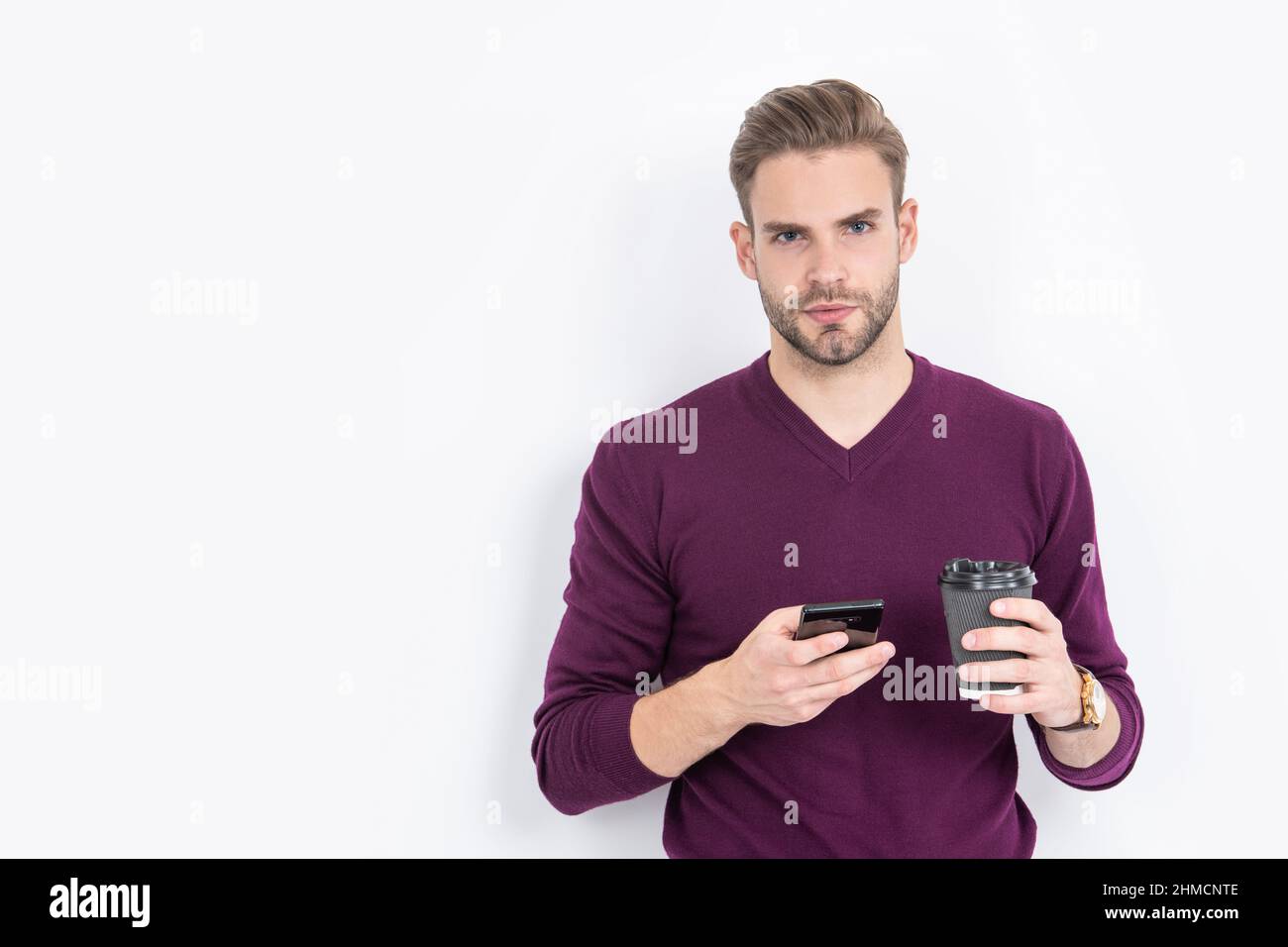 Caféine et addiction au smartphone. Un homme charmant utilise le téléphone pour boire du café. Dépendance à la technologie Banque D'Images