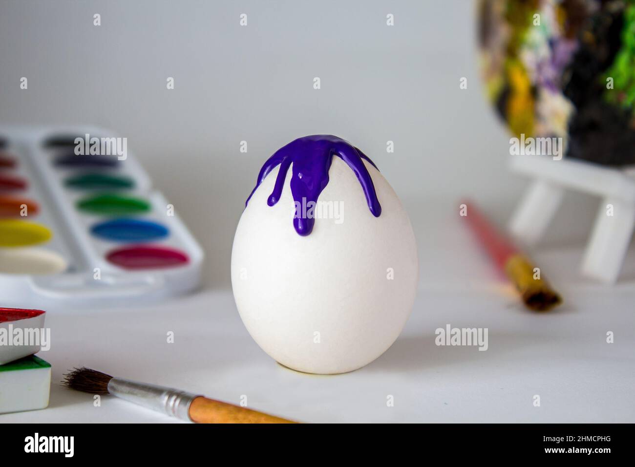 Œuf de Pâques blanc sur fond aquarelle. Composition de vacances simple. Symbolisme du concept du festival des oeufs de Pâques. Travail d'art, fait main, créativité Banque D'Images