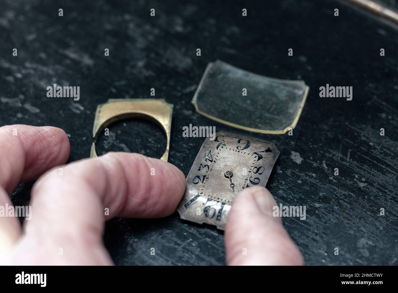 une montre vintage démontée et une main d'un maître, tenant un mécanisme, un gros plan intérieur Banque D'Images