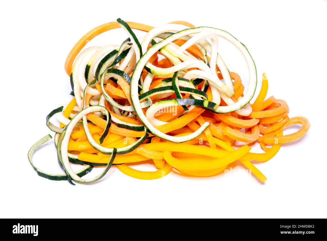 Nouilles de légumes crus faites de courgettes, de courges et de carottes sur fond blanc Banque D'Images