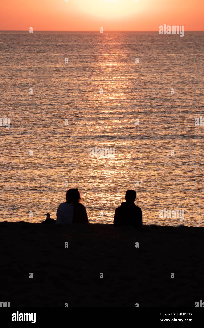 couple regardant le lever du soleil sur la plage de pals en méditerranée Banque D'Images