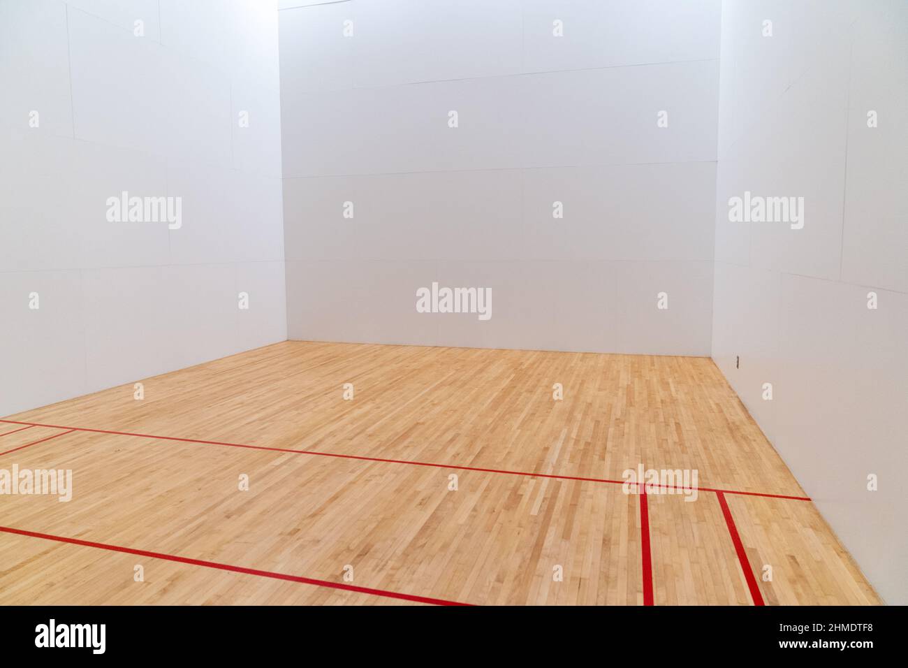 À l'intérieur d'un terrain de raquetball, avec des marquages rouges, des murs blancs et des planchers en bois Banque D'Images