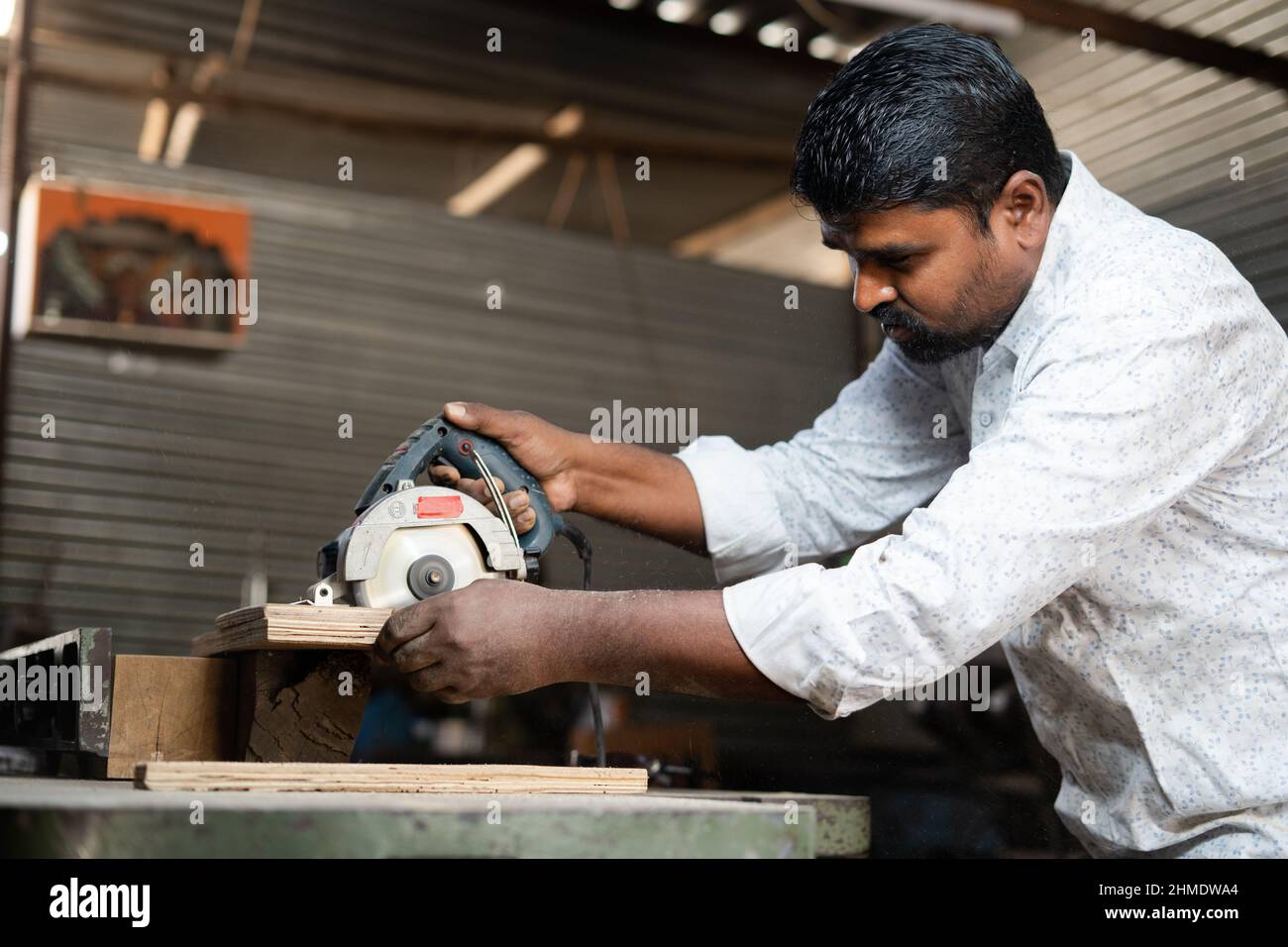 Concentrez-vous sur la machine, le menuisier indien de polissage du bois en utilisant des outils de menuiserie à l'atelier - concept de travail indépendant, petite entreprise et indépendant. Banque D'Images