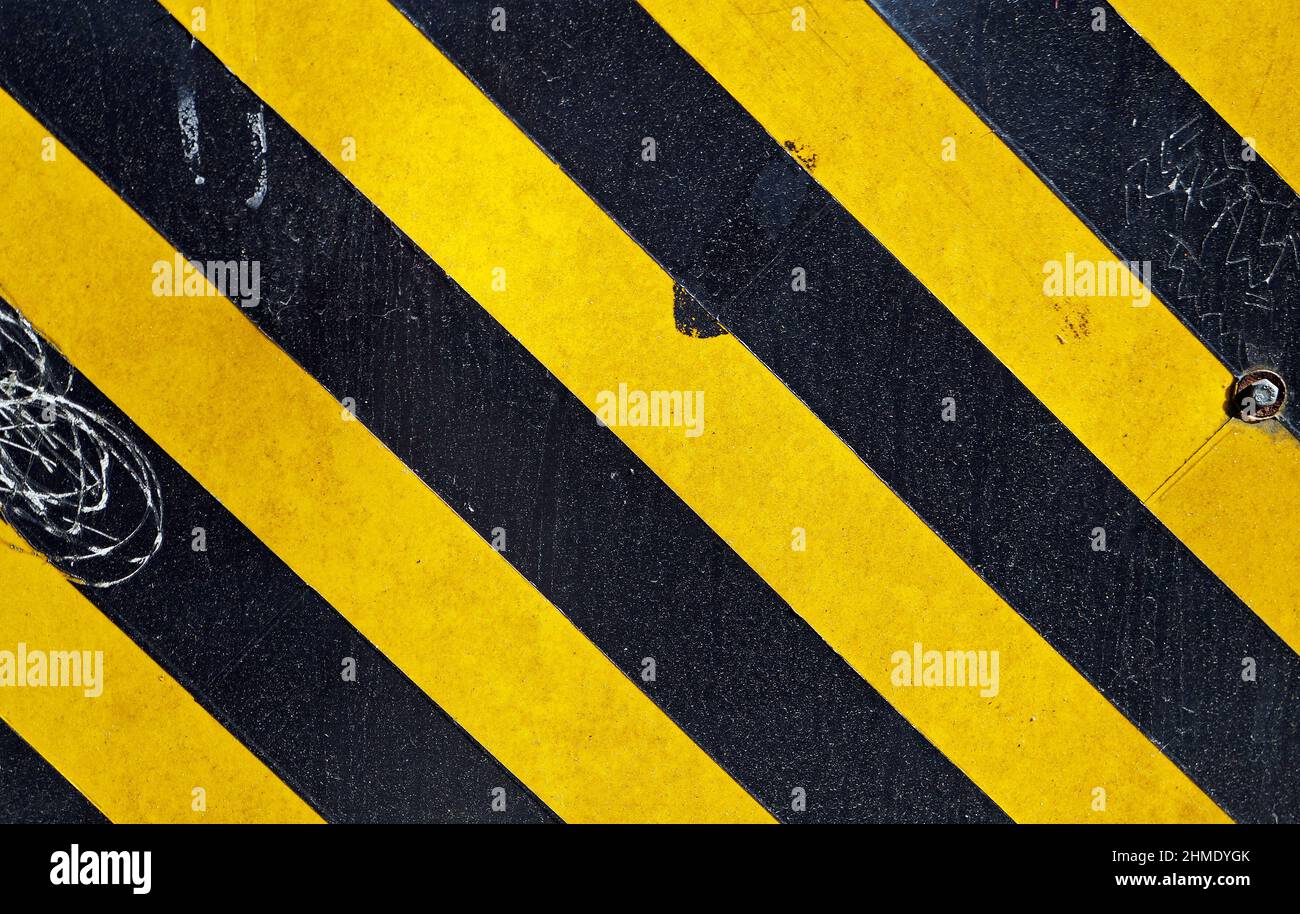 Surface métallique peinte avec des bandes noires et jaunes Banque D'Images