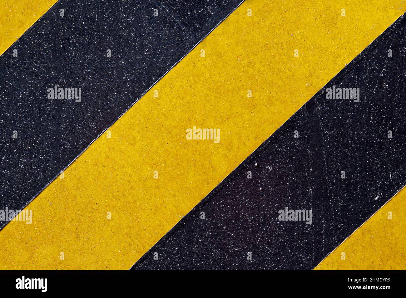 Surface métallique peinte avec des bandes noires et jaunes Banque D'Images