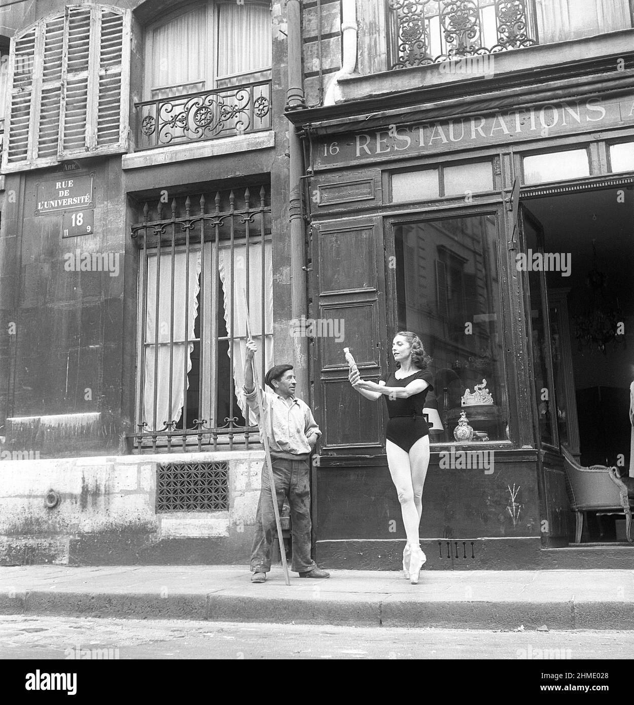 Danseuse de ballet en 1950s. Ellen Rasch, 1920-2015, danseuse suédoise et images d'actrice à Paris France debout sur ses orteils tenant un ancien à l'extérieur d'un magasin pendant qu'un nettoyeur de rue regarde, a suspendu son travail. 1951 photo Kristoffersson réf. BD26-5 Banque D'Images