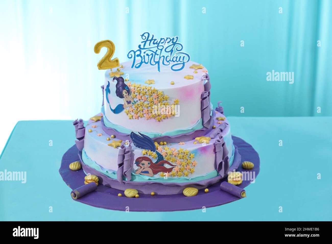 Gâteau d'anniversaire sur le thème de la princesse au design et à la décoration magnifiques, composé de beurre violet et rose et de glaçage fondant avec perles couronne Banque D'Images Gâteau d'anniversaire sur le thème de la princesse au design et à la décoration magnifiques, composé de beurre violet et rose et de glaçage fondant avec perles couronne Banque D'Images