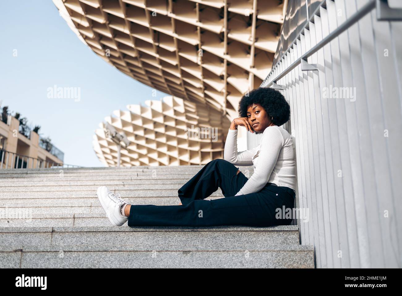 Belle adolescente noire assise sur quelques marches dans la rue Banque D'Images