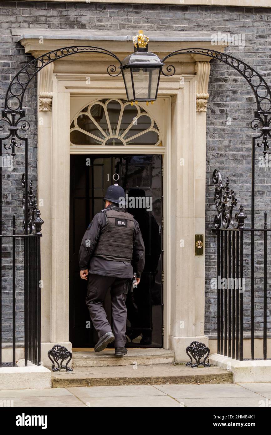 Un policier entrant dans la célèbre porte noire du numéro 10 Downing Street, Londres, Royaume-Uni Banque D'Images