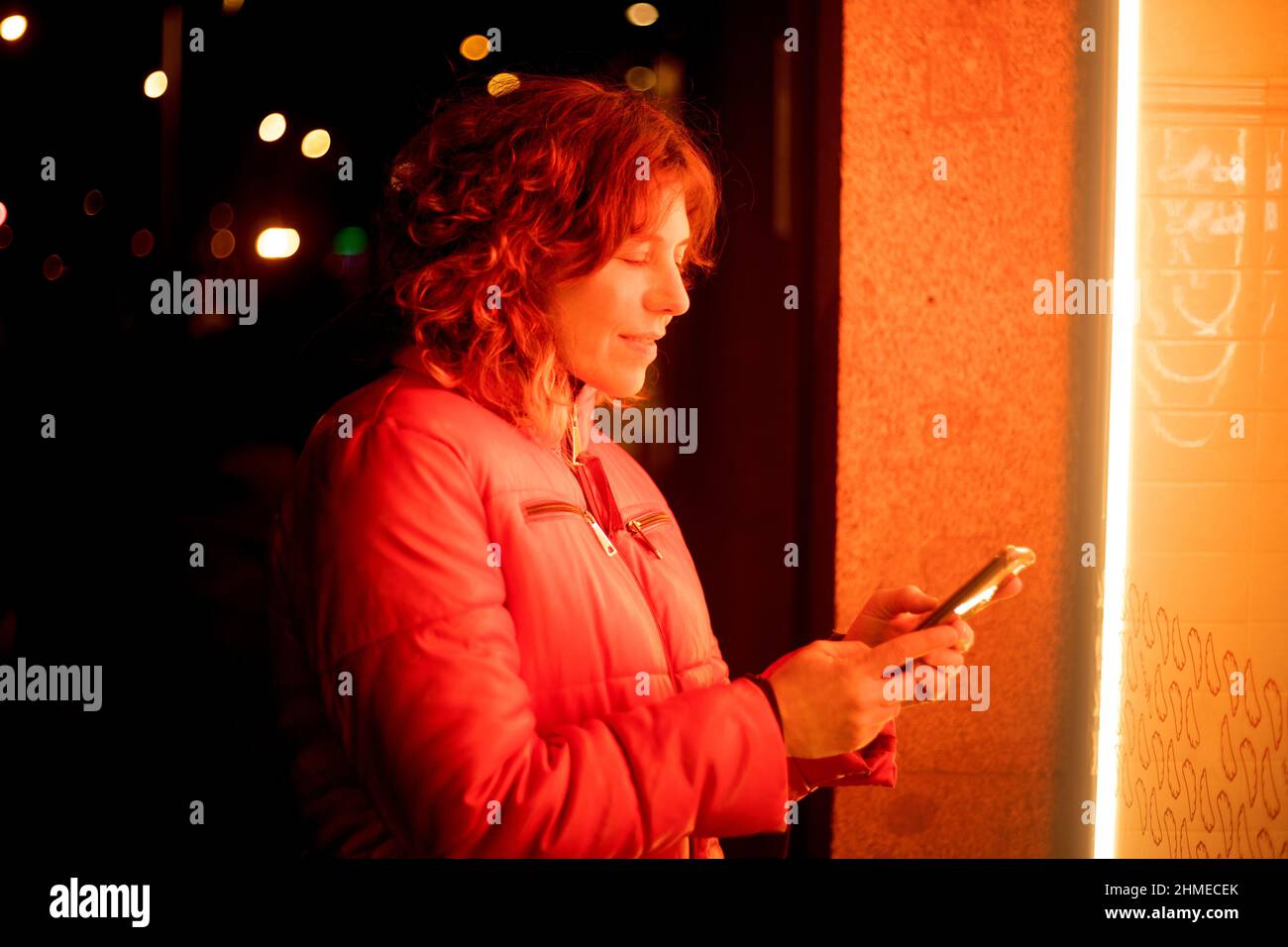 femme de nuit avec des lumières utilisant son téléphone cellulaire Banque D'Images