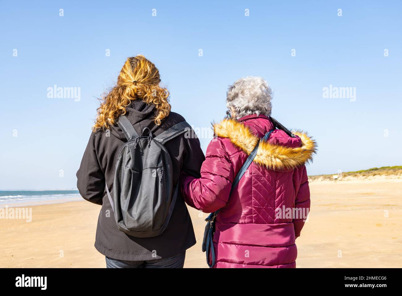Une femme mûre marchant avec sa mère âgée près de la plage à l'automne Banque D'Images