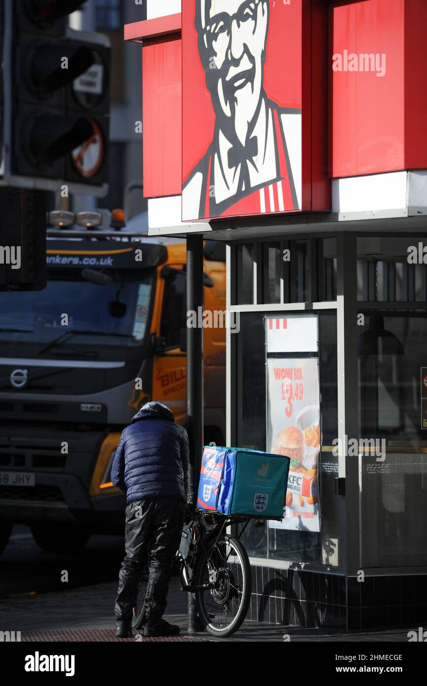 Un vélo deliveroo attend à l'extérieur du restaurant de restauration rapide de poulet frit du Kentucky pour une commande à préparer pour la livraison. Banque D'Images