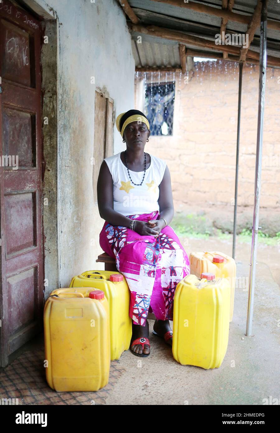 Une femme à l'extérieur de sa maison dans une zone rurale de Sierra Leone, en Afrique de l'Ouest. Banque D'Images